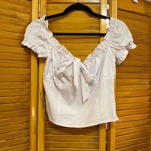 White top with bow and fringe details